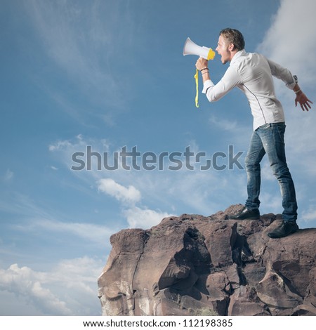 Boy screaming on the megaphone in the mountain
