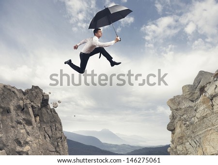 Businessman jumping over the mountains