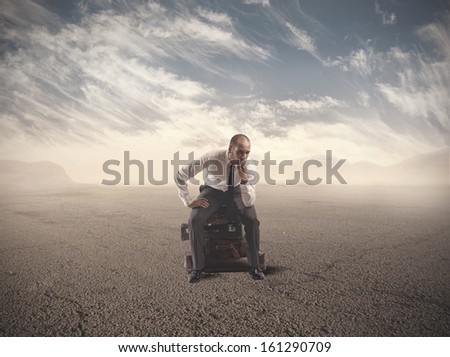 Concept of lost businessman confused sitting on suitcases