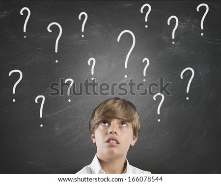 Young boy uncertainty about the future with question marks