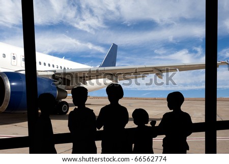Silhouette of people against modern airplane