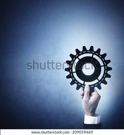 Teamwork and integration concept with businessman that holds a gear
