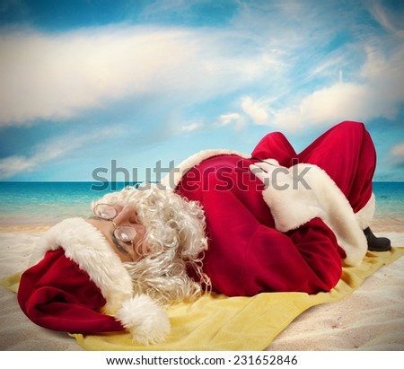 Santa Claus lying sunbathing on a beach