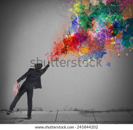 Young and creative businessman colors with spray