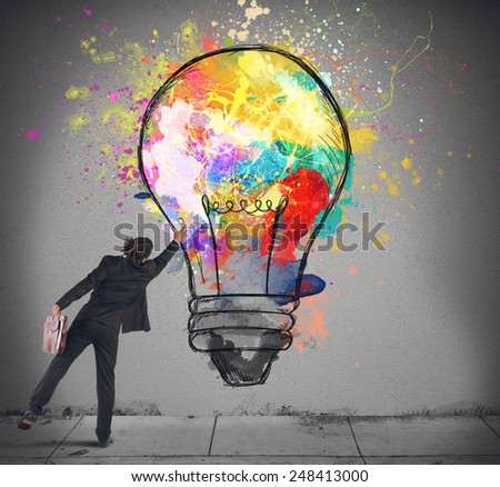 Businessman color with a spray a lightbulb