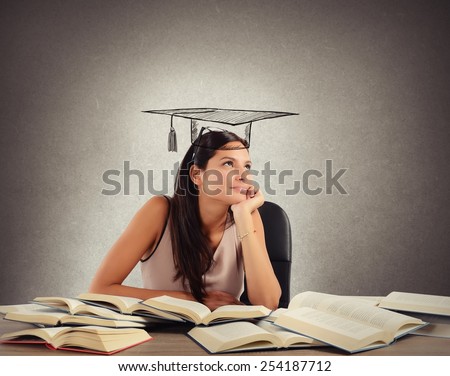 Young student between books dreams the graduation