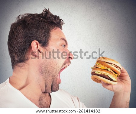 Insatiable and hungry man eating a sandwich