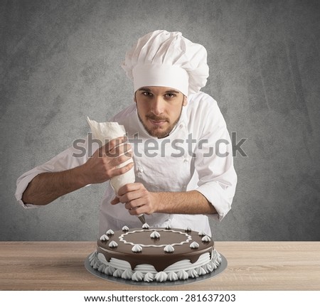 Pastry cook prepares a chocolate and cream cake