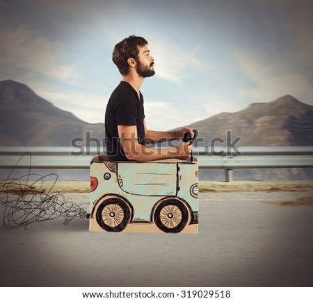 Boy driving cardboard car in mountain road