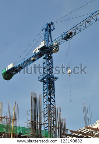 Blue tower crane on construction site with blue sky