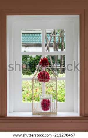 White window ,White window with red flowers on an old tree house facade