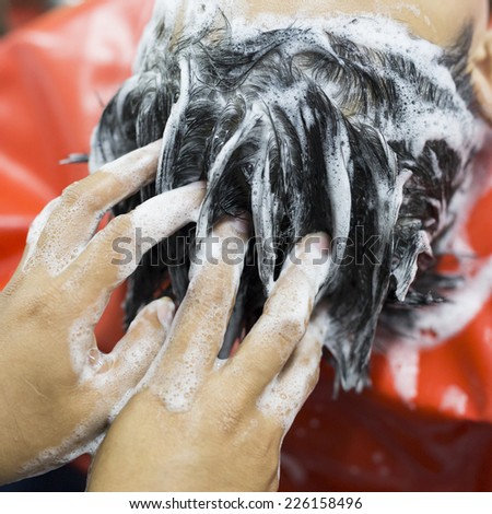 Closeup photo of woman washing hair with shampoo