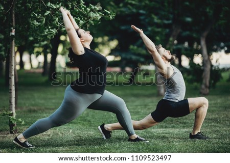 Overweight woman working out with personal trainer. Individual training outdoors. Fitness, sport, training, weight loss, teamwork and lifestyle concept.