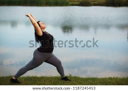 Overweight woman training near lake, copy space. Healthy lifestyle, sport, weight losing, activity concept