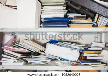 Declutter concept - lots of books, papers, boxes on shelf - chaos, clutter, mess, unorganized