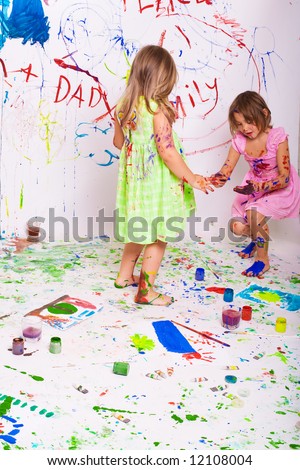 two beautiful girls play together with paints