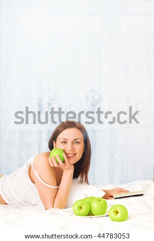 beautiful smiling woman with apples and book in morning