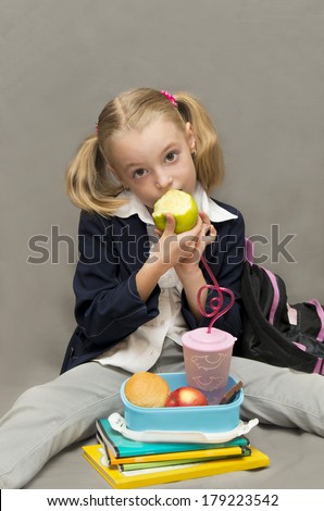 Break for lunch.Schoolgirl at lunch, eating an apple.Back to school.