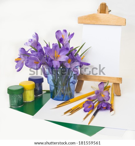 Postcard , purple spring crocus flowers in a glass with brushes, paints for drawing.