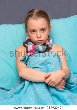 Sad child is sitting on the bed.