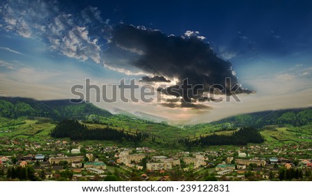 Landscape mountain town with a stormy,dramatic sky in the late spring.