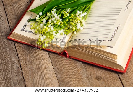 lily of the valley flowers on the book for records  on wooden background
