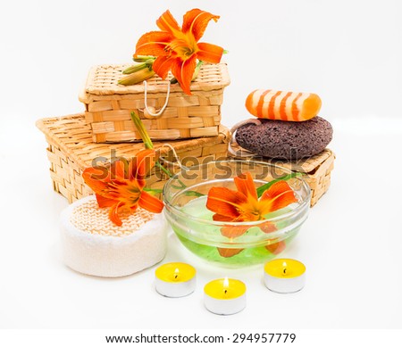 Spa concept. Orange lily flowers, boxes, sea salt, candles, soap  and objects for spa procedures on a white background