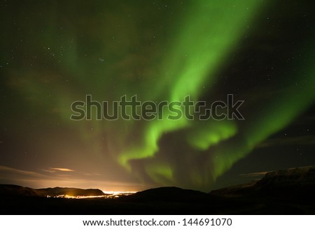Aurora Borealis with city in the background-close to Reykjavik in Iceland