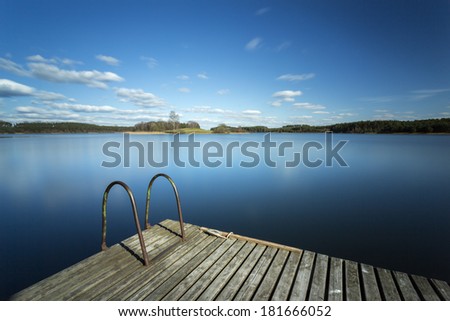Wooden pier on lake in north Poland. Long exposure and motion in sky/Wooden pier long exposure