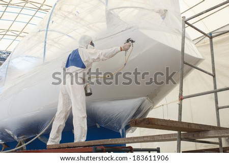 Man spraying paint to the boat