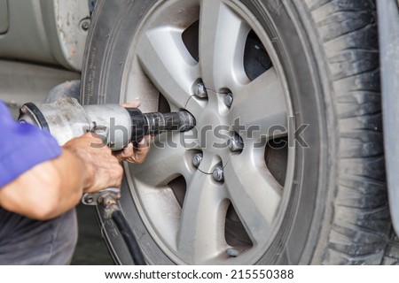 Car wheel changed by auto mechanic