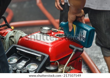 Hand of man fill oil to the engine