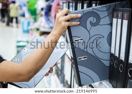 Hand of woman holding color paper in department store