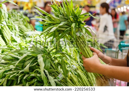 Hand holding vegetable in department store