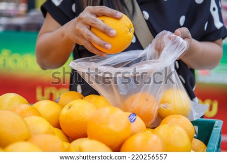 Hand holding orange in department store