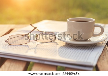 Close up glasses on newspaper and Coffee on the table in the morning