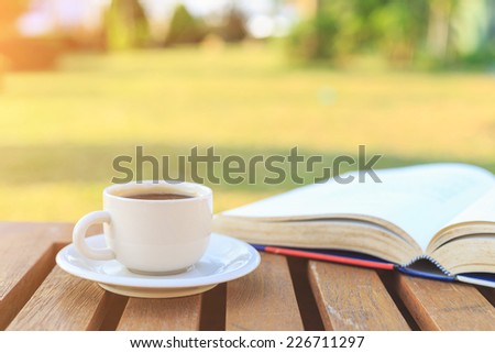 Coffee cup and book on table in the garden