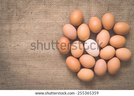 Eggs on old crumpled burlap background with retro filter effect