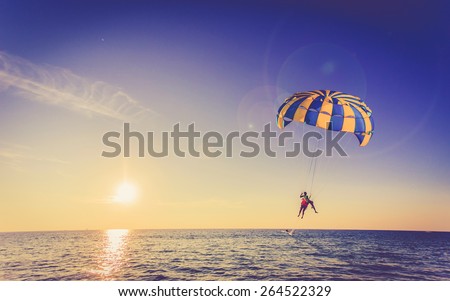 Tourist is para sailing over the blue sea in Thailand, Vintage color