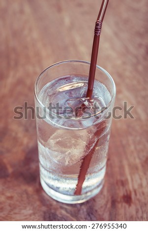 Close up drinking water with ice in glass on wooden table