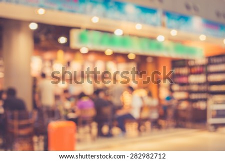 Blurred image of people in coffee shop at the airport, with retro filter effect