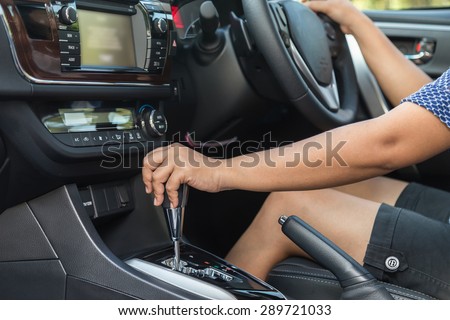 Close up driver left hand shifting the gear stick in car