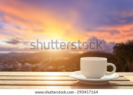 Close up coffee cup on wood table at sunset or sunrise time
