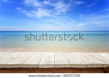 Empty top of wooden table or counter and view of tropical beach. For product display