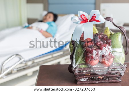 Close up fruits basket and female patient on the bed in hospital room