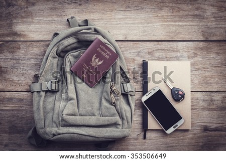 Top view Thailand passport, backpack, smartphone, car key and book on wood plank background? Vintage filter effect