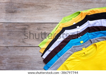 Top view of color T-Shirt on grey wood plank background