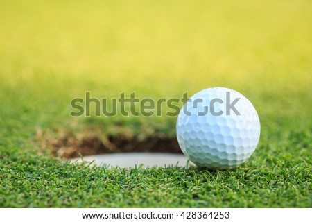 Close up golf ball on lip of cup  in course