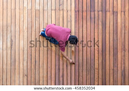 A worker painting exterior wooden pool deck, Top view