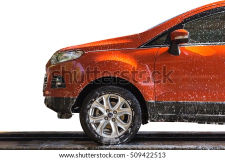Orange car with white soap on the body in car care shop. Isolated on white background